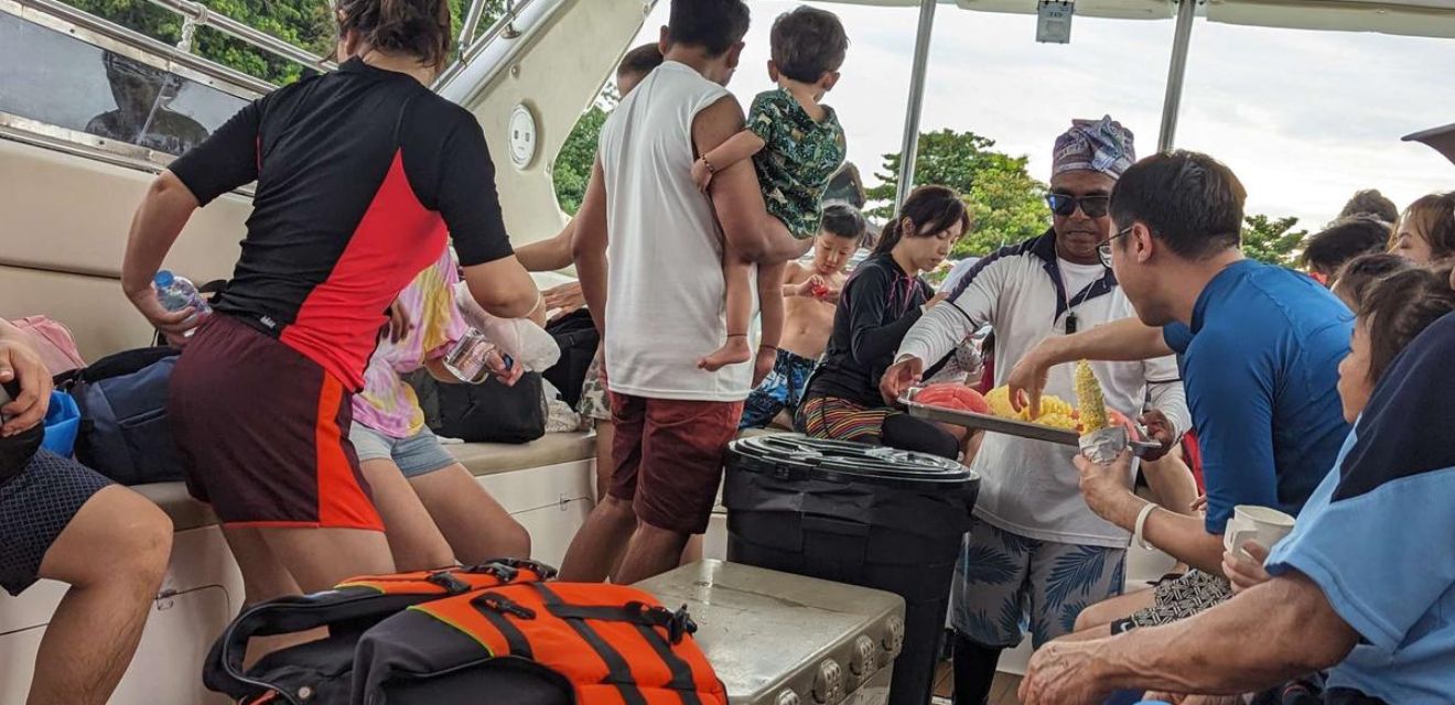 guide on group shared speedboat tour phi phi handing out fruit