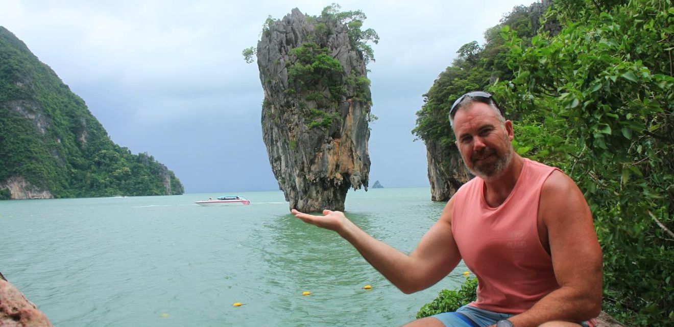 tourist man holding up island photo classic james bond phang nga tour